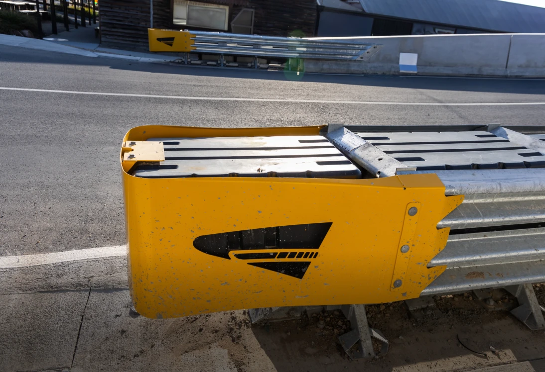 Yellow road barrier with black arrow